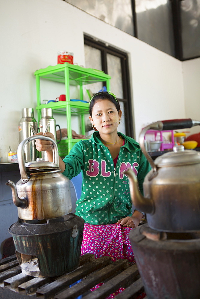 Local woman preparing tea in a huge kettle, Mandalay, Myanmar, Southeast Asia