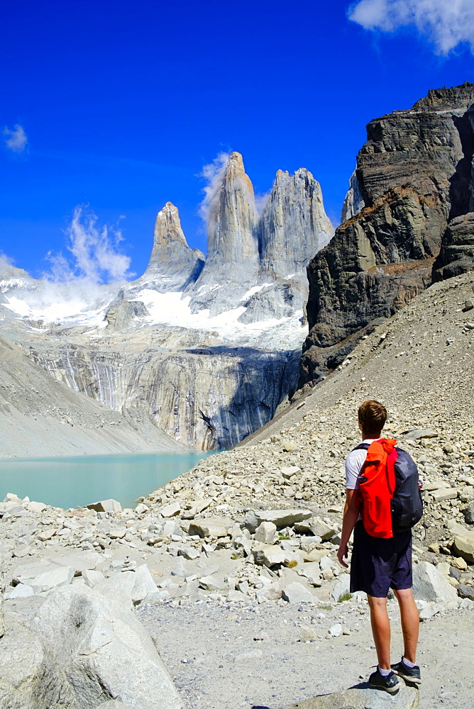 Hiker in front of the rock towers that give the Torres del Paine range its name, Torres del Paine National Park, Patagonia, Chile, South America