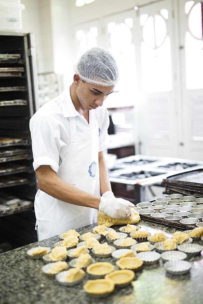 A baker making Portuguese custard tarts in the Confeitaria Colombo, a famous cafe in central Rio de Janeiro, Brazil, South America