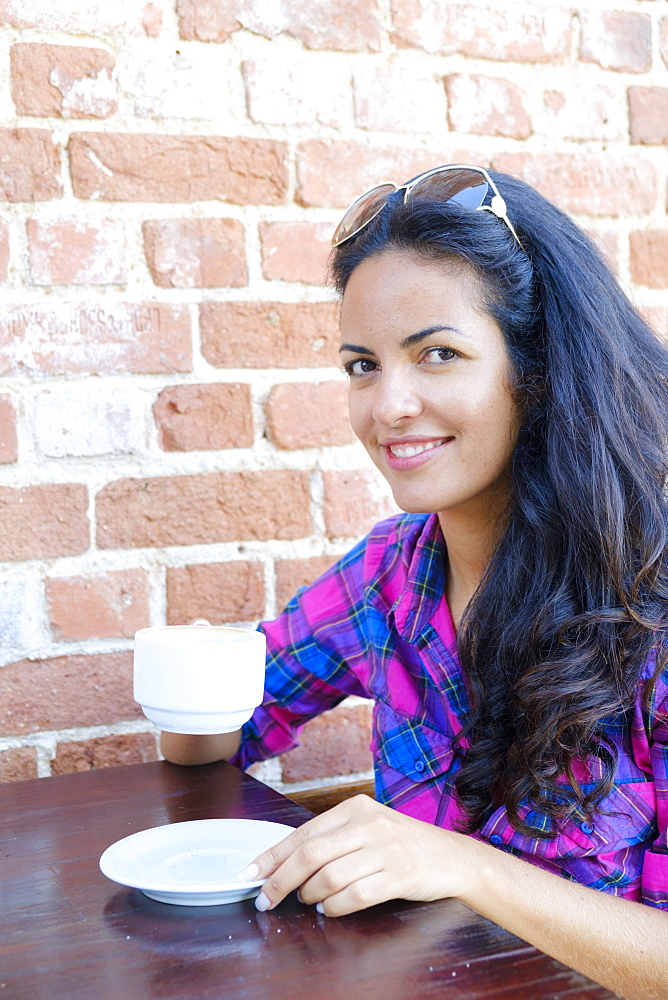 Young Brazilian (Latin American) (Latina) woman, 20 to 29 years old drinking coffee in a Rio cafe, Rio de Janeiro, Brazil, South America