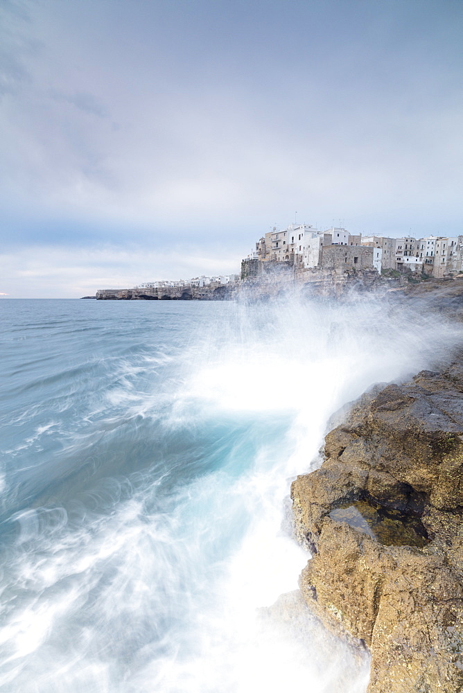 Waves of turquoise sea crashing on cliffs framed by the old town, Polignano a Mare, Province of Bari, Apulia, Italy, Europe