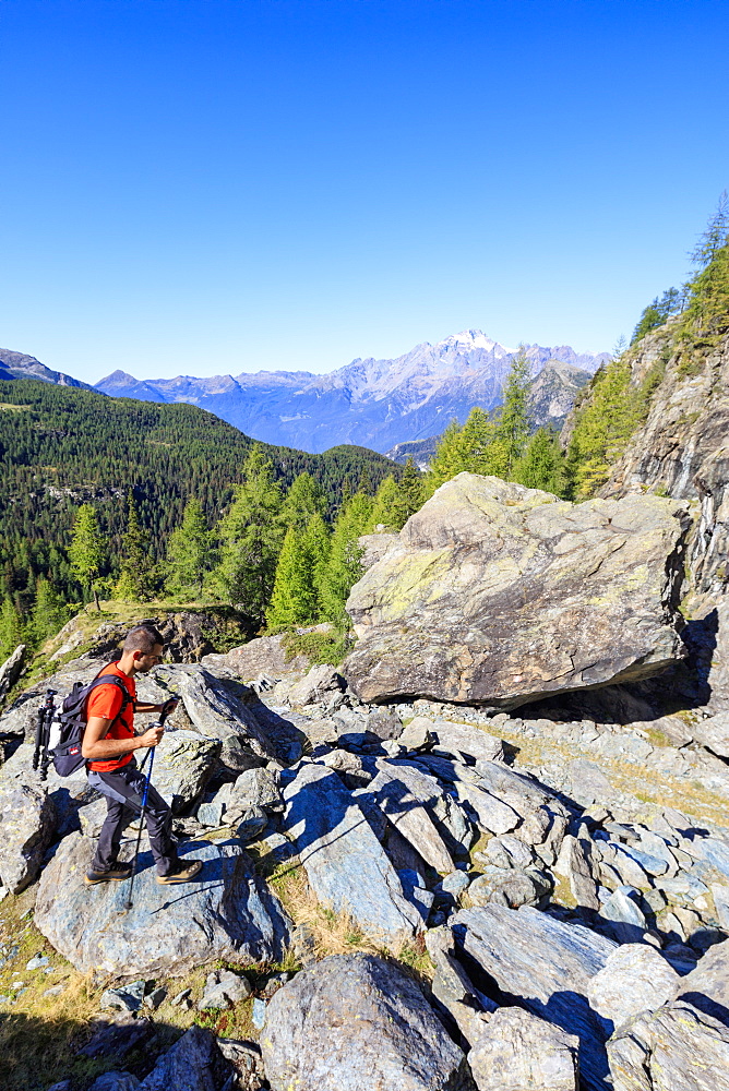 Hiker on the rocky path proceeds towards the Lake Mufule, Malenco Valley, province of Sondrio, Valtellina, Lombardy, Italy, Europe