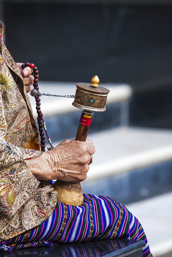 A faithful Buddhist uses the traditional portable roller-book (prayer wheel), Bhutan, Asia