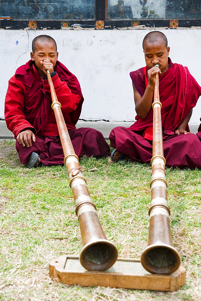 Monks playing Dungchen trumpet, Punakha, Bhutan, Asia