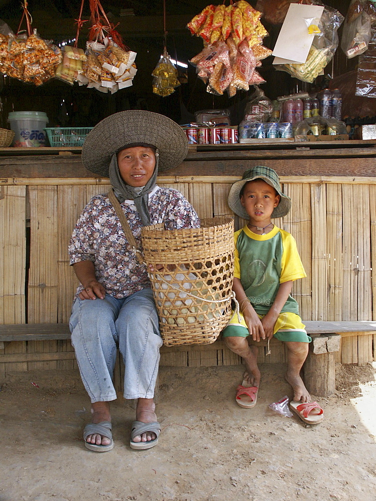 Thailand mother and child sitting in front of shop nasiri village of the lahu tribe, chiang mai