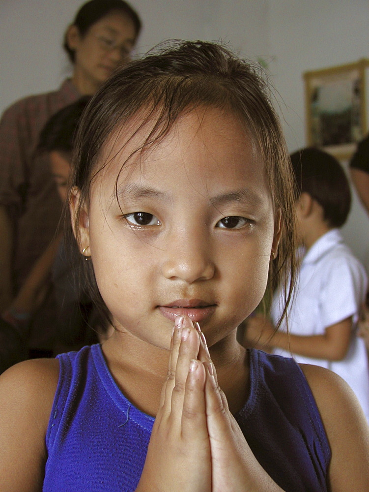 Thailand girl giving traditional greeting at a school for burmese migrants, bangkok