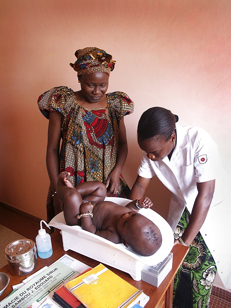 Senegal woman weighing her at a routine clinic service cnter, dakar