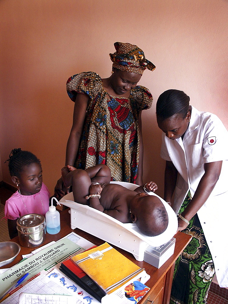 Senegal woman weighing her at a routine clinic service cnter, dakar