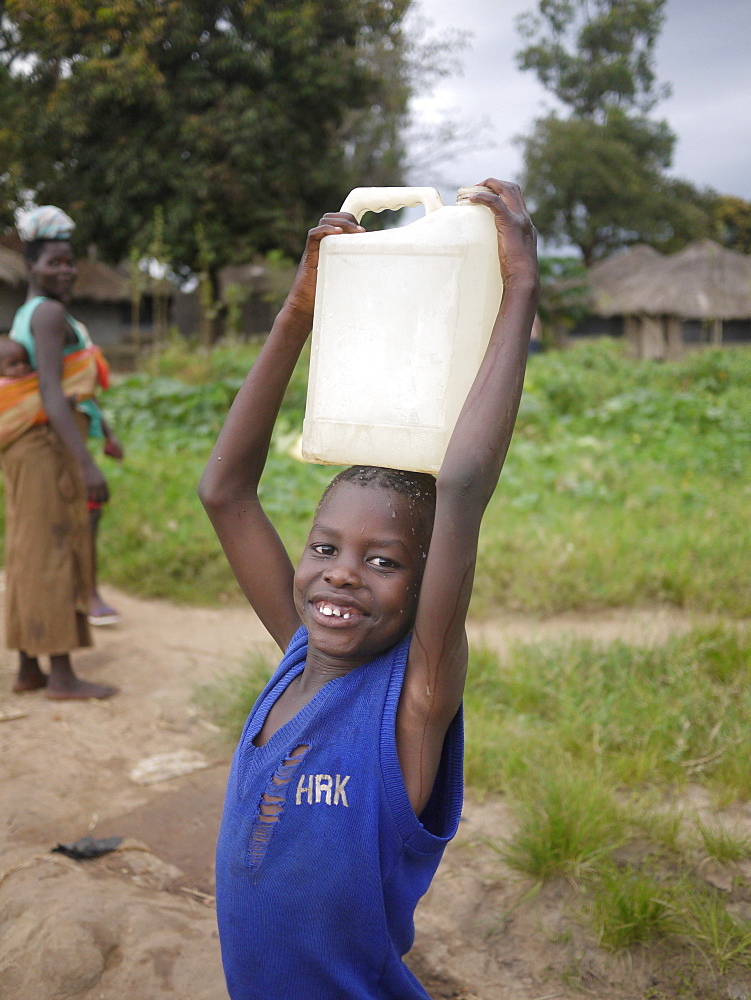 UGANDA Collecting water from hand-pumped well, Gulu. PHOTO by Sean Sprague