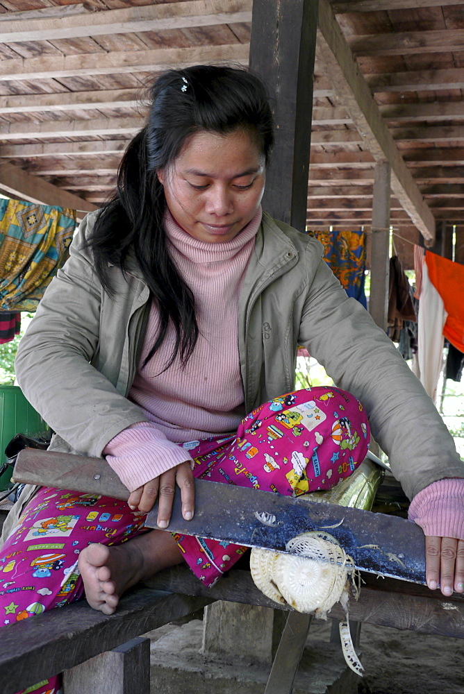 CAMBODIA Woman cutting banana stem for cooking. Ban Bung village, Stung Treng district