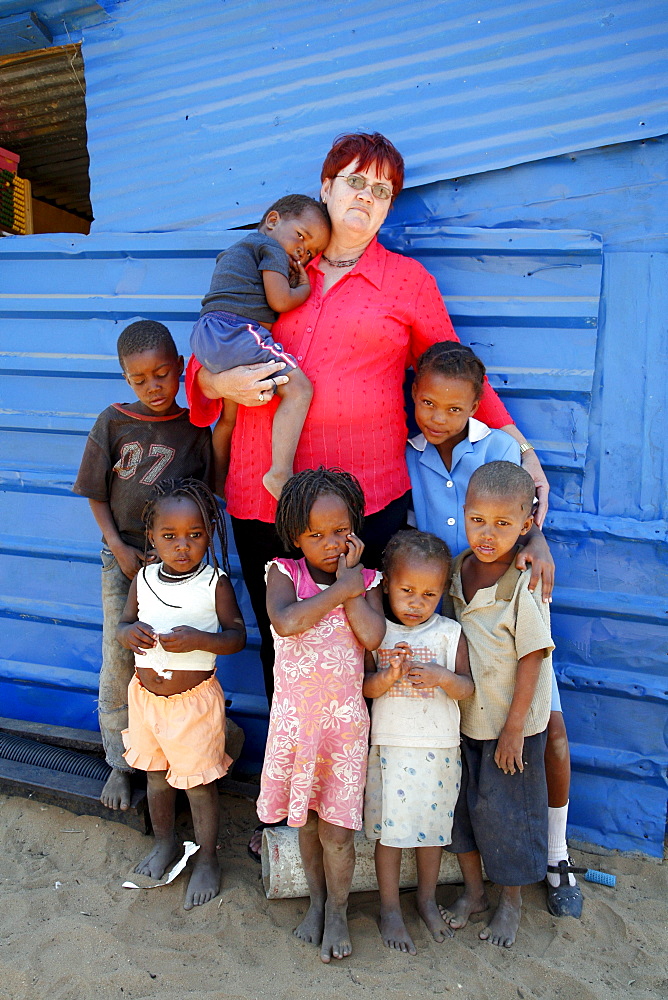 Namibia woman with poor children standing in front of their -school in rehobeth