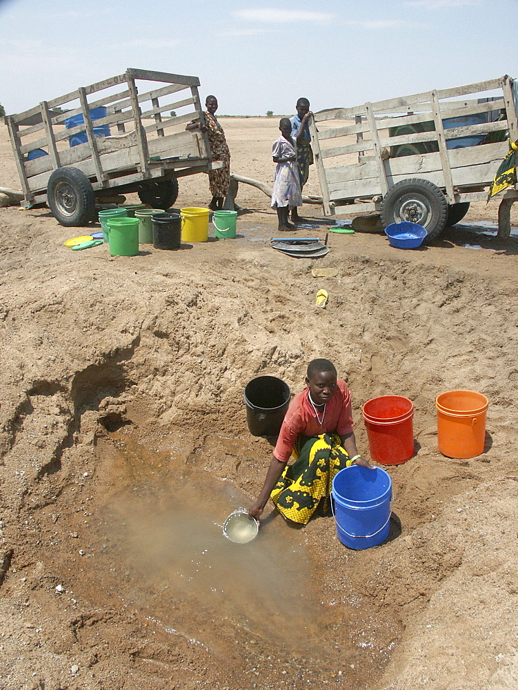 Water, tanzania taking water from a dirty hole in a dry river bed, shinyanga