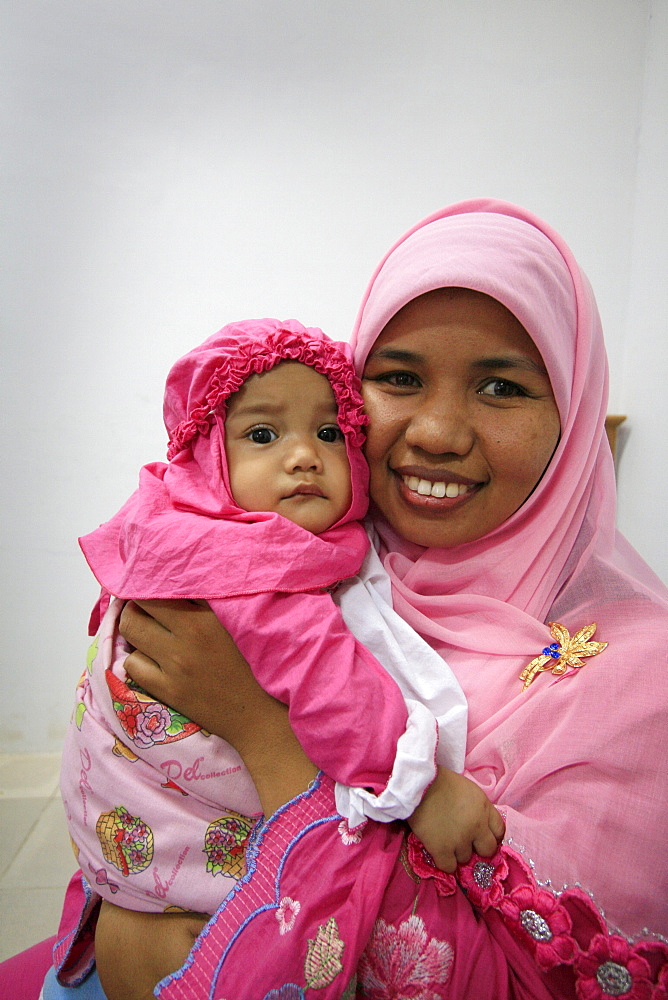 Indonesia mother child built in banda aceh by. Photograph taken in banda aceh, -december 2006, 2 years after tsunami of december 26th 2004 devasted much of coastal region. Taken to illustrate reconstruction work projects of (catholic relief services) of sponsored photo tour 