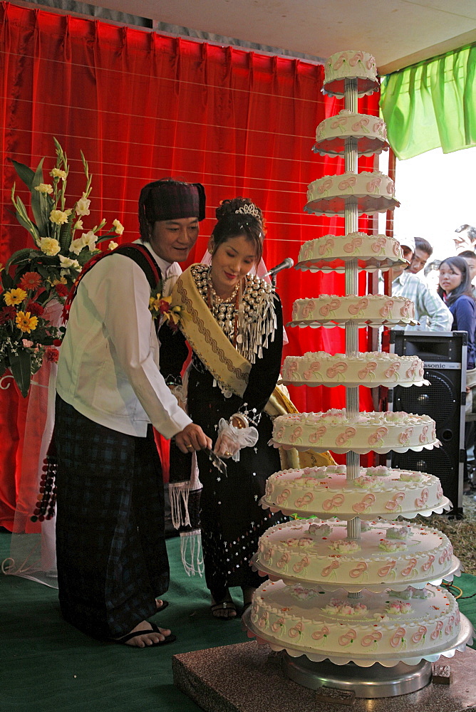 Myanmar bride groom cutting cake, catholic wedding of tribal kachins at myitkyina, a largely kachin community in north burma near chinese border 