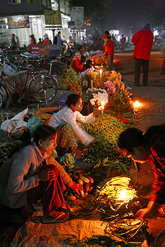 Myanmar traders selling food from candle stalls at night market at myitkyina, a largely kachin community in north burma near chinese border 