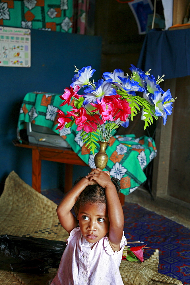 Fiji girl holding artificial flowers on her head, taveuni photo by sean sprague