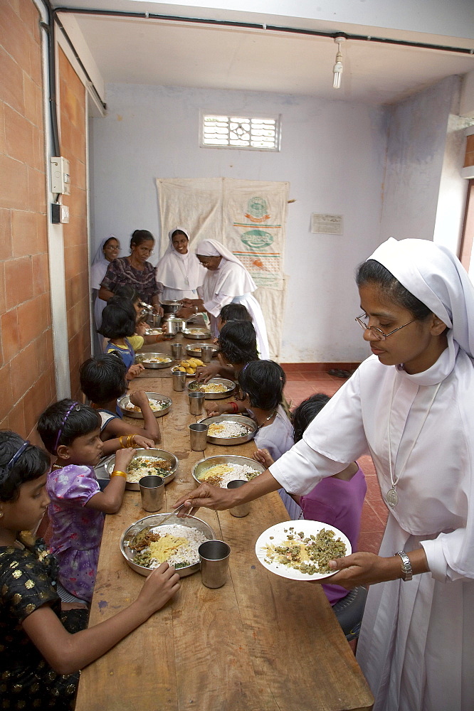 India. Sister bincy joseph aruviyil serving, during mealtime at the mary matha bala bhavan, a girls orphanage run by syro-malabar catholic missionary sisters of mary immaculate (msmi), chamal village, thamarassery diocese, khozikode, kerala. 2007   