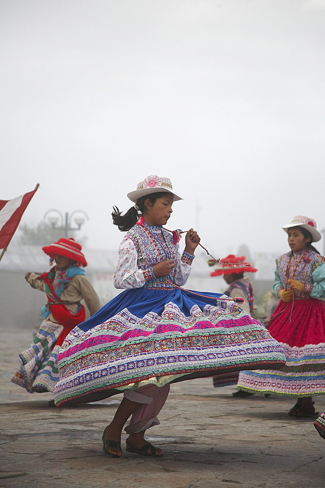 Peru. Children in traditional costume dancing at yanque, colca canyon