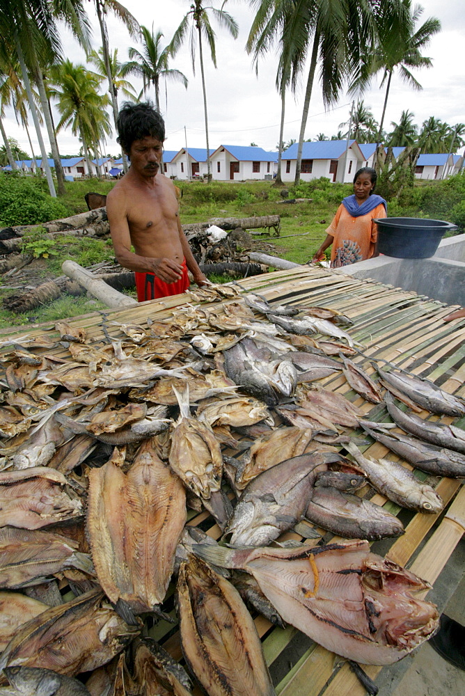 Indonesia crs housing project at seunebok tuengoh relocation site. zaman, a fisherman, smoking fish. meulaboh, aceh, two years after the tsunami