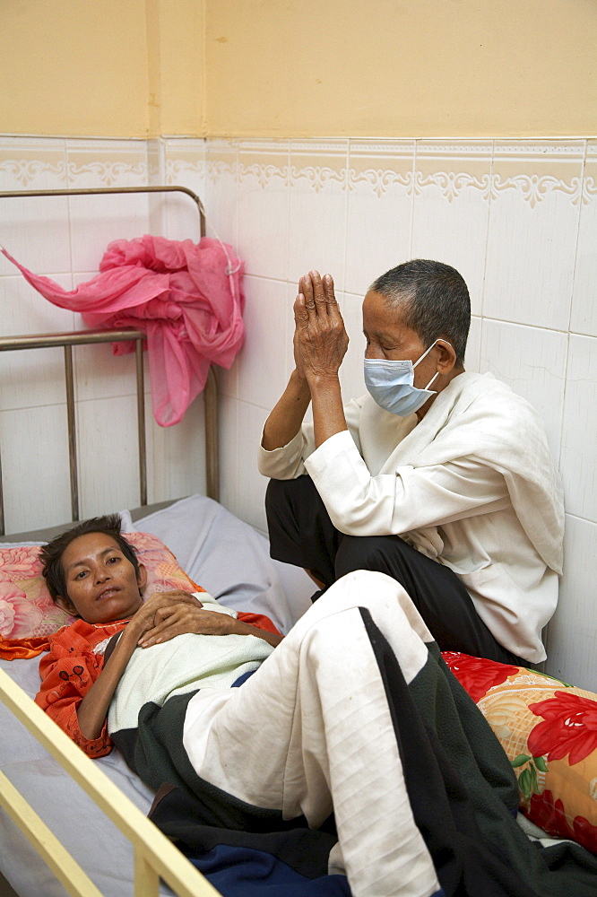 Cambodia seedlings of hope hospice for aids patients, phnom penh. woman saying buddhist chants to another who is dying of aids