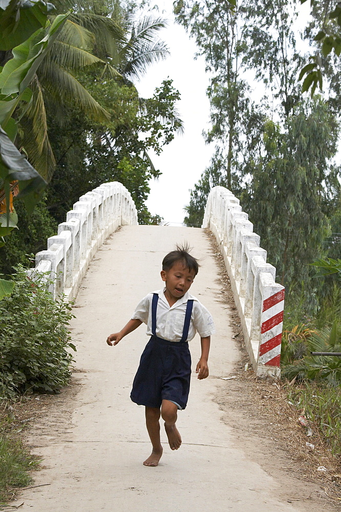 Vietnam hoa binh commune in vinh long province. this bidge across a river and next tohoa binh primary school, was constructed by crs (catholic relief services) to help the kids get to their classes. previously many of them had to walk several miles in order to attend school