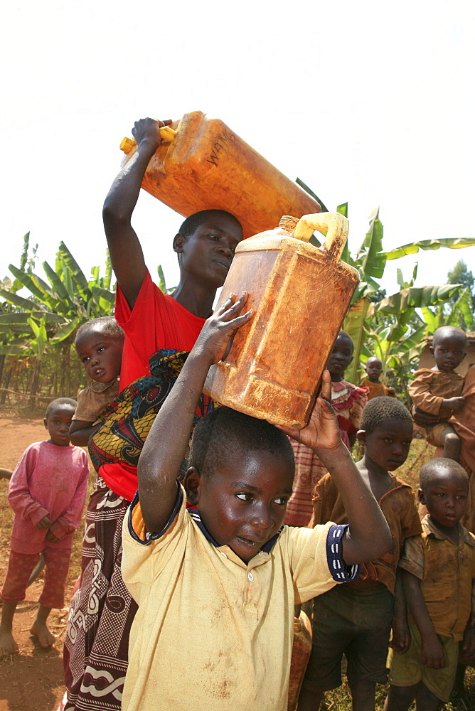 Burundi woman and her son carrying water from a stand pipe located 300 metres from their home.