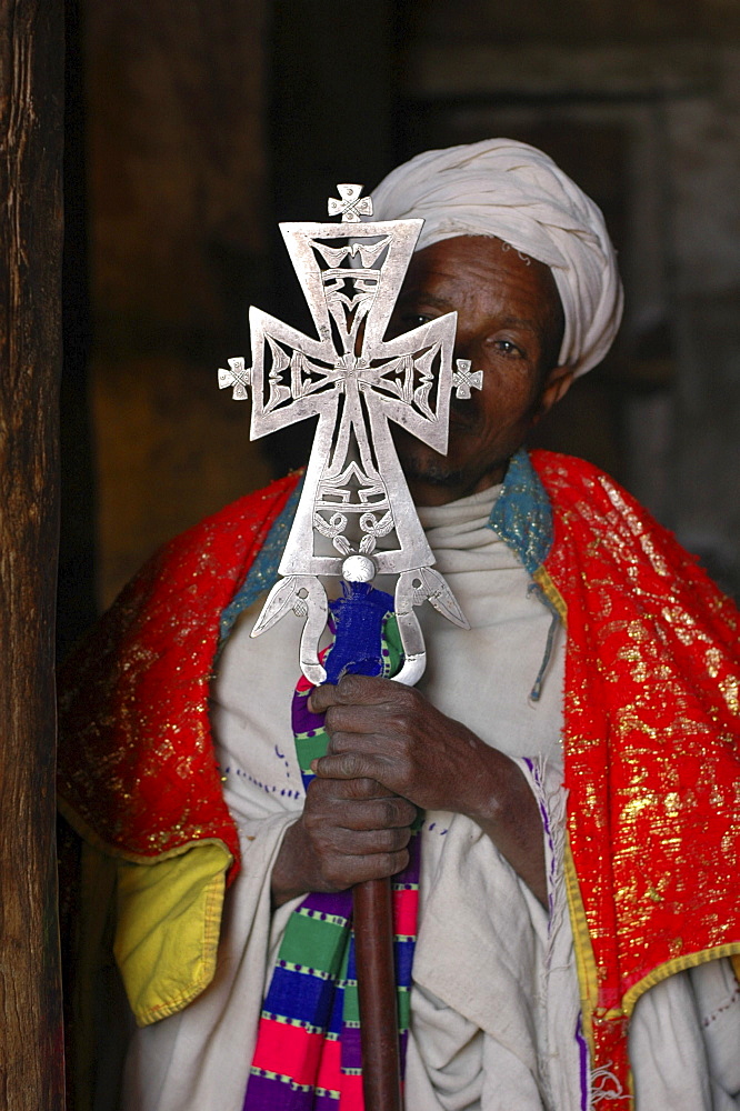 Religion, ethiopia. Geneta maryam, a church 31 kms from lalibela, built around 1270 by yekuno amlak. Priest at the church holding an ancient cross