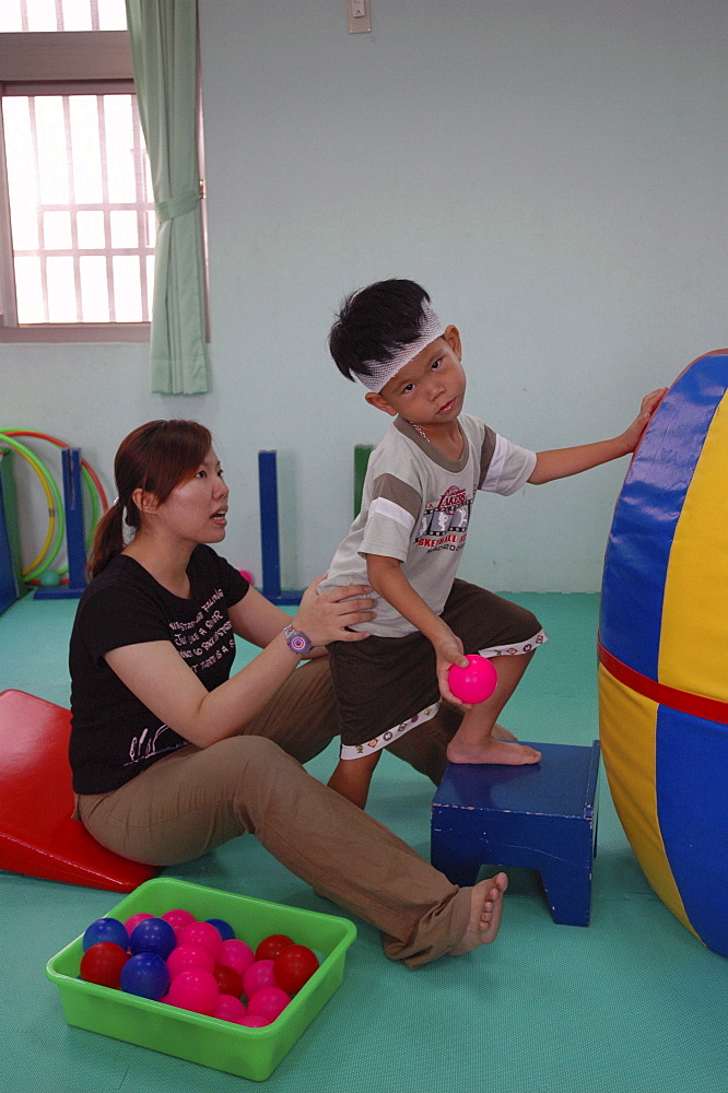 Disability, taiwan. A school for children with special needs, tainan. Boy receiving therapy