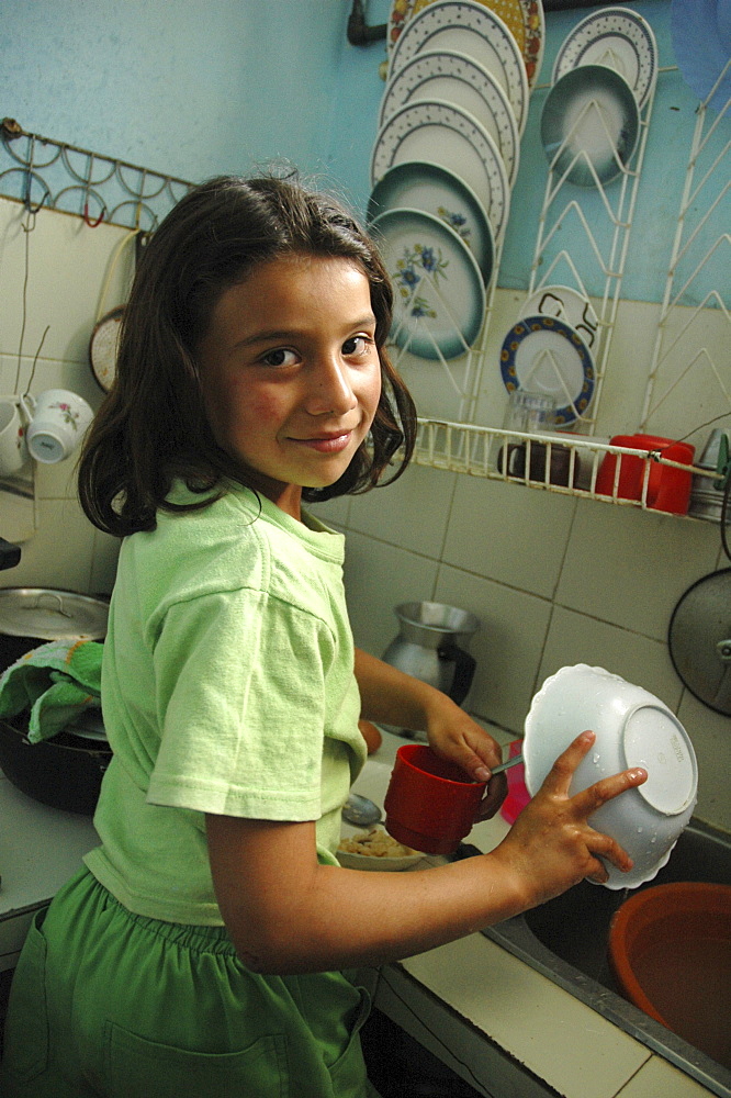 Colombia marly juliet, 7, of the slum of altos de cazuca, bogota, washing dishes