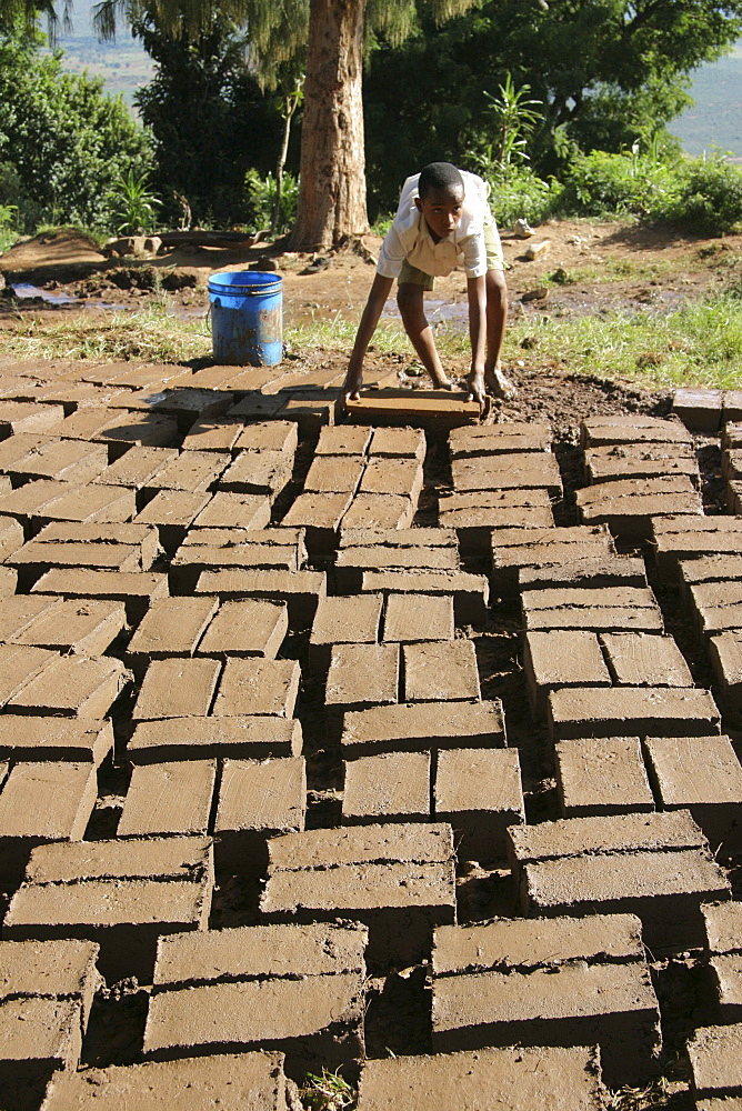 Tanzanian school boy making mud bricks. Kisangara, same, in the north-east near kilimanjaro