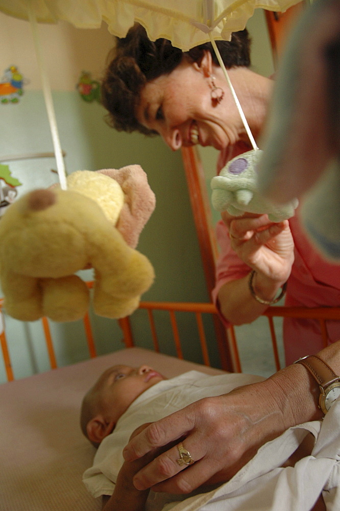 Cambodia american volunteer kathy kremmer taking care of sick babies at an orphanage in pnom penh