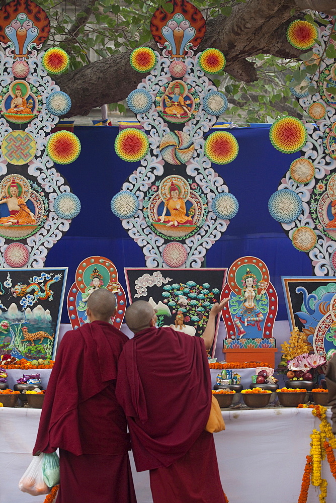 Buddhist monk praying butter statues that is made under the bodhi tree inside mahabodhi temple complex. Kalachakra initiation in bodhgaya, india  