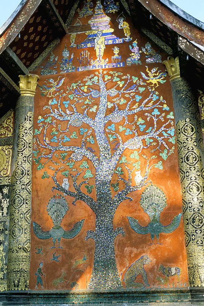 Glass mosaic of tree of life on wall of the 16th century Sim, Wat Xiang Thong, Luang Prabang, UNESCO World Heritage Site, Laos, Indochina, Southeast Asia