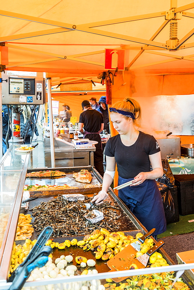 Vendor cooking on grill at market in Helsinki, Finland, Europe