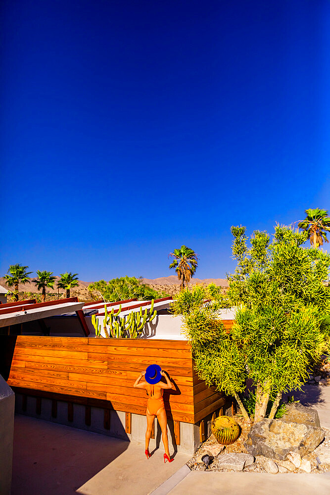 View of beautiful desert home and woman getting a tan, Palm Springs, California, United States of America, North America