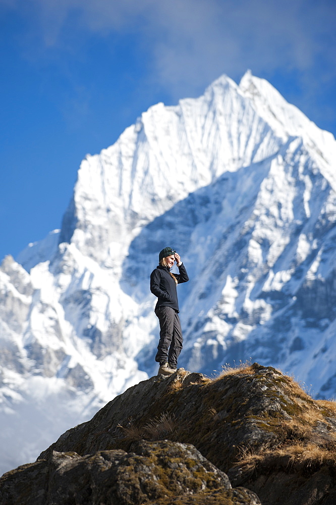 A trekker enjoys the views above Namche in the Everest region with views of Thermserku in the distance, Himalayas, Nepal, Asia