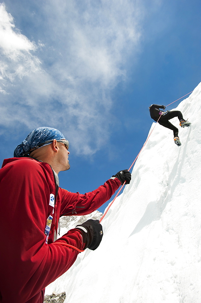 A climber makes her way down an ice wall in preparation for climbing Everest, Khumbu Region, Nepal, Asia