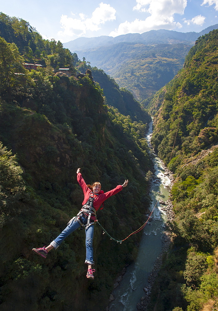 A girl jumps a canyon swing, Nepal, Asia