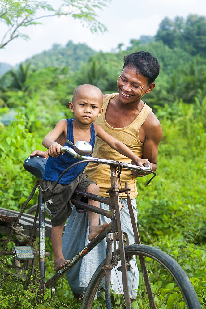 A man balances his little boy on his bicycle, Chittagong Hill Tracts, Bangladesh, Asia