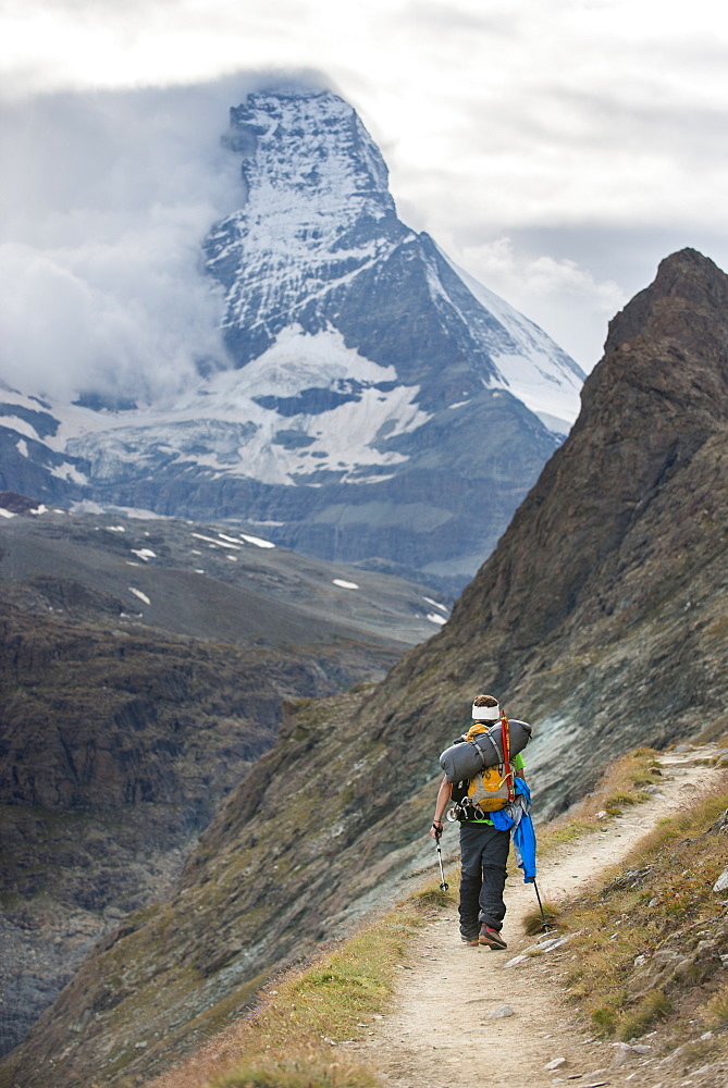 Hiking a trail in the Swiss Alps near Zermatt with a view of The Matterhorn in the distance, Zermatt, Valais, Switzerland, Europe