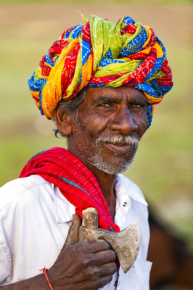 A farmer wearing traditionally brightly coloured turban in the dry state of Rajasthan, India, Asia