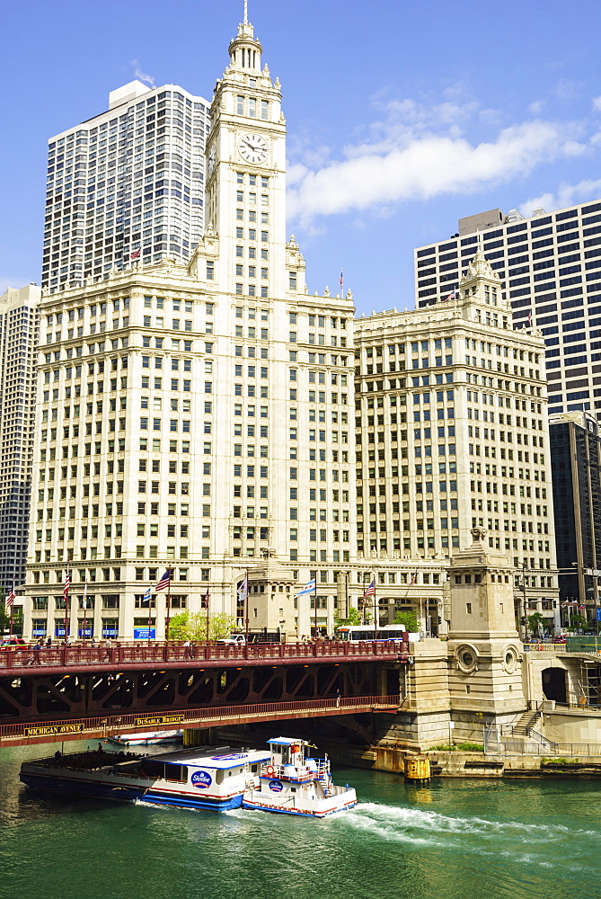 Sightseeing boat passing under DuSable Bridge on the Chicago River with Wrigley Building behind, Chicago, Illinois, United States of America, North America