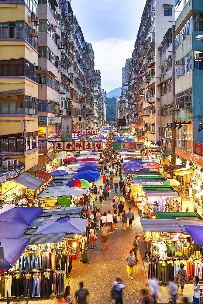 A busy market street in Mong Kok (Mongkok) lit up at dusk, Kowloon, Hong Kong, China, Asia