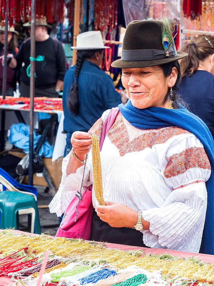 Indigenous woman buying gold necklace, market, Plaza de los Ponchos, Otavalo, Ecuador, South America