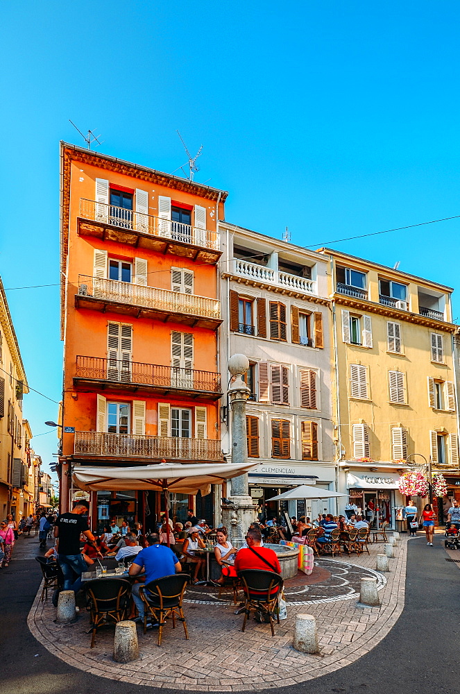 Tourists at a cafe on a street corner and traditional Provencal architecture in Antibes, Cote d'Azur, Provence, French Riviera, France, Europe