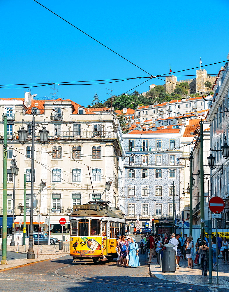 Traditional yellow tram at Praca da Figueira with Castelo Sao Jorge at background, Lisbon, Portugal, Europe