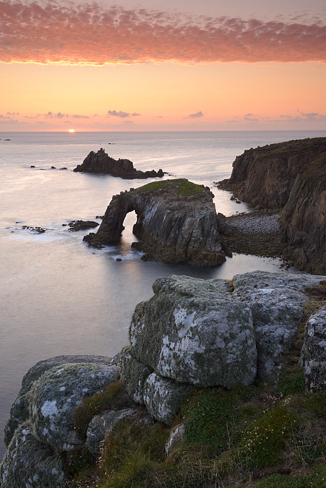 A colourful sunset overlooking the islands of Enys Dodnan and the Armed Knight at Land's End, Cornwall, England, United Kingdom, Europe