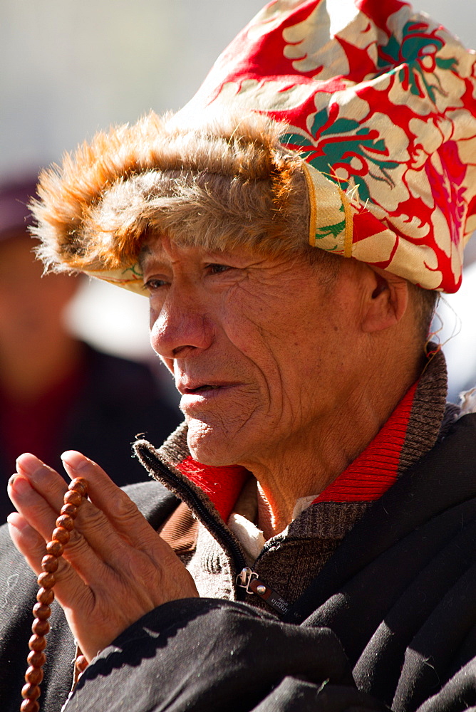 Man praying at the Jokhang Temple of Barkhor Square, Lhasa, Tibet, China, Asia