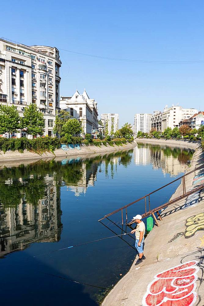 A fisherman on the Dimbovita River in Bucharest, Romania, Europe