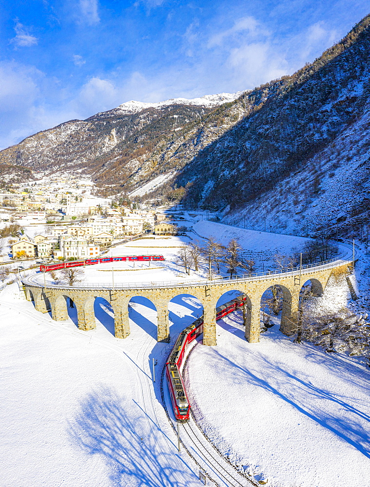 Bernina Express passes under the helical (spiral) viaduct of Brusio, UNESCO World Heritage Site, Valposchiavo, Canton of Graubunden, Switzerland, Europe